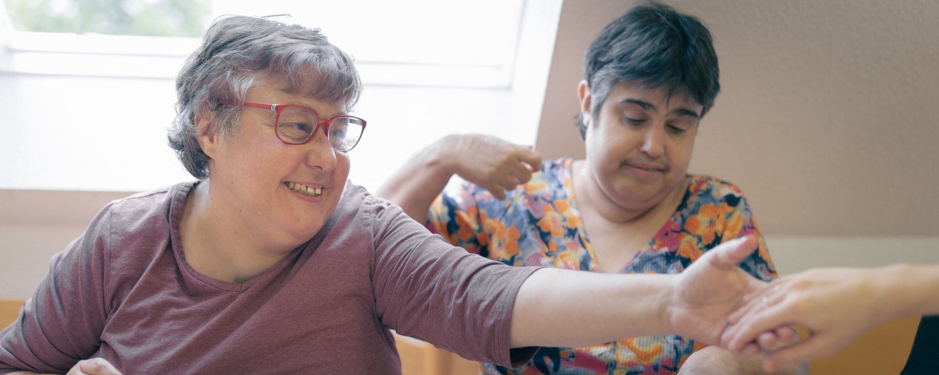 Zwei behinderte Frauen legen gemeinsam ein Puzzle zusammen
