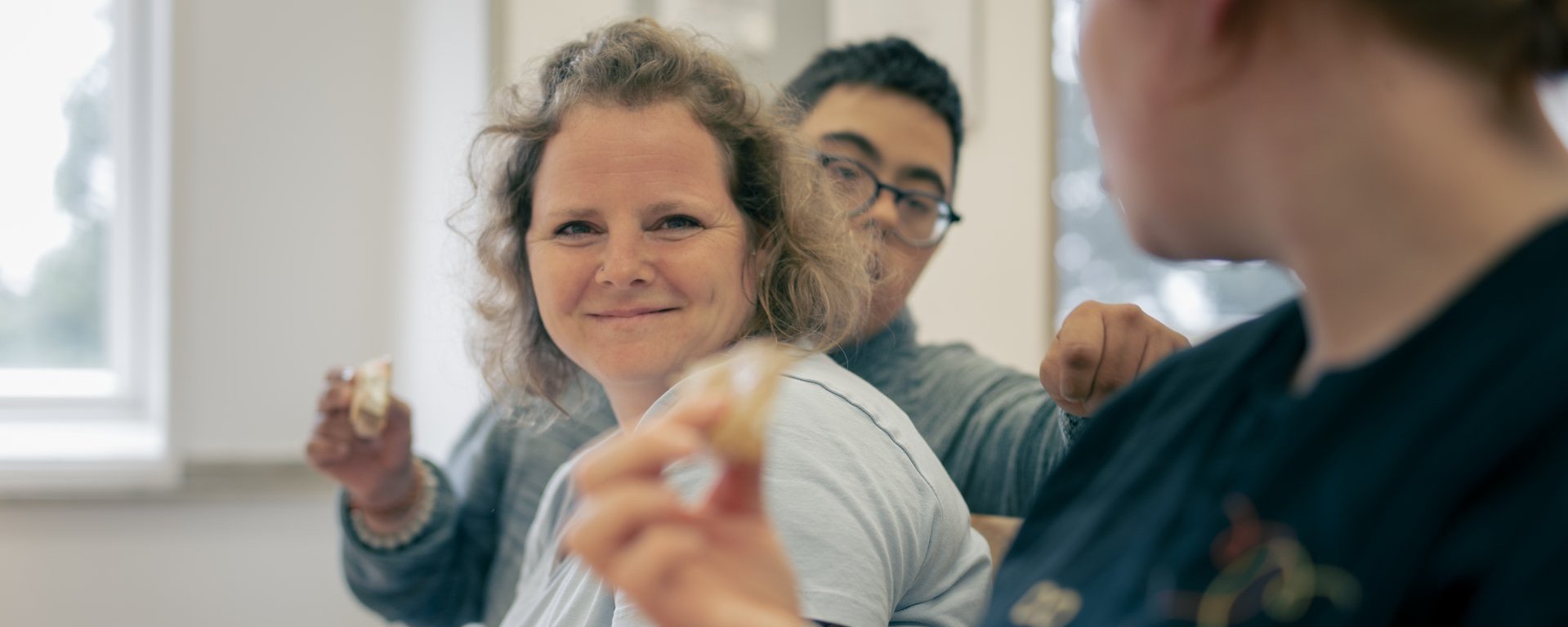 Pflegerin sitzt mit Behinderten Kinder am Tisch und Isst