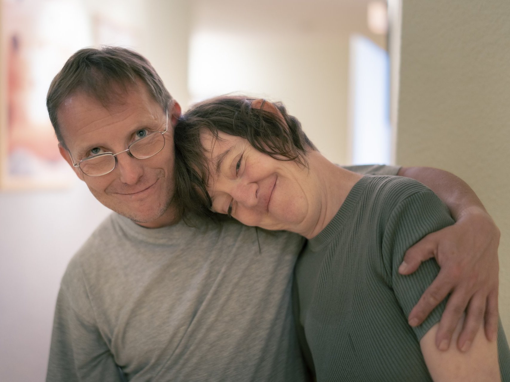 Ein Erzieher und eine beeintraechtigte Person umarmen sich herzlich