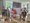 Eine Gruppe von neun Menschen steht in einem hellen Raum vor Whiteboards mit Notizen und Skizzen. Die Personen tragen lässige Sommerkleidung und posieren lächelnd für ein Gruppenfoto.